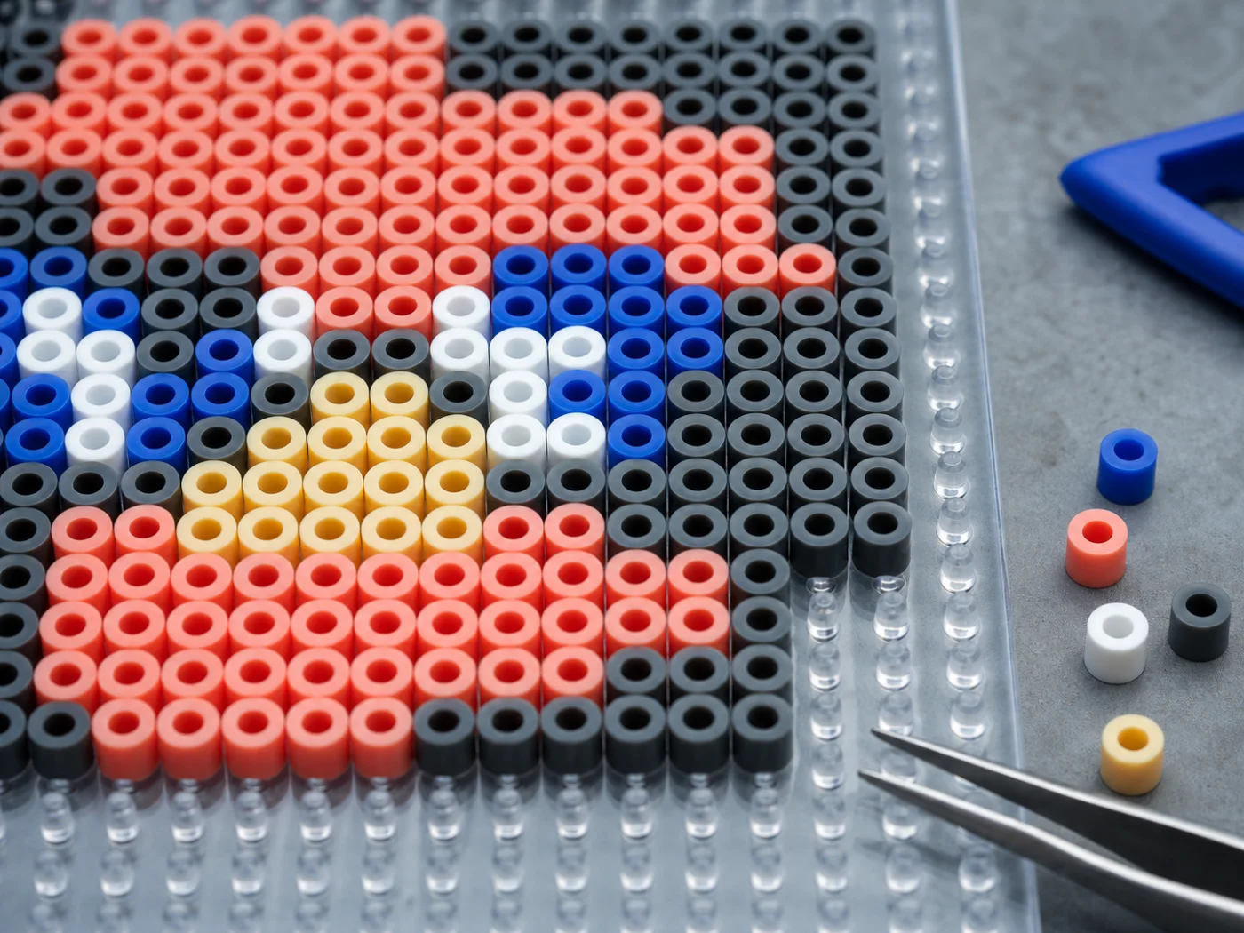 Macro view of colorful fuse beads arranged on a transparent pegboard